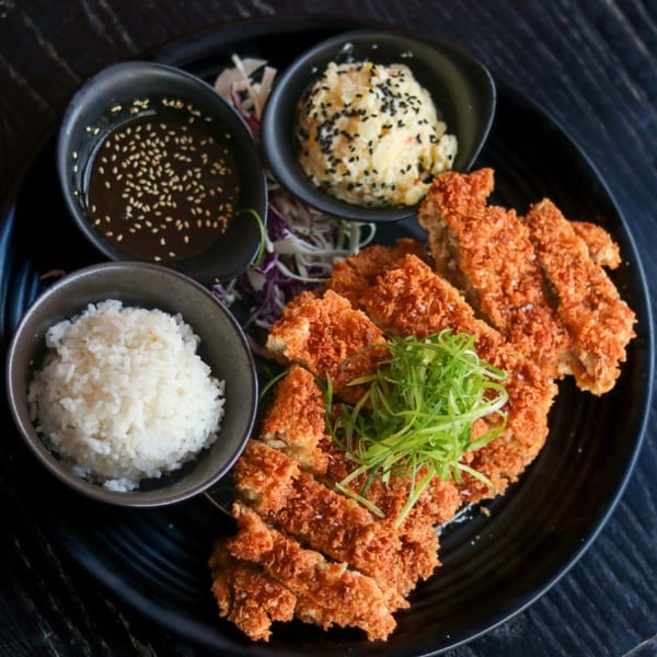 Crispy Boru Ramen chicken katsu, rice, potato salad, and dipping sauce on a black plate.
