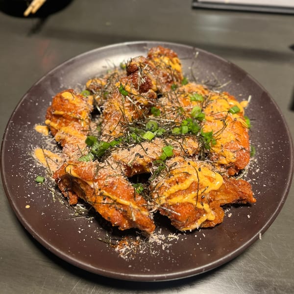 Boru Ramen's fried chicken karaage, drizzled with sauce, topped with seaweed, green onions, and sesame seeds.
