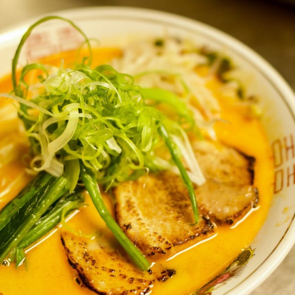 Close-up of Boru Ramen's spicy ramen with pork belly, green onions, and bean sprouts.