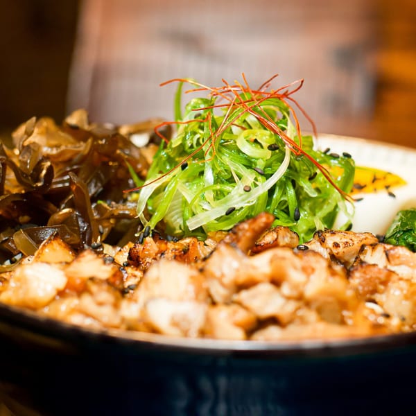 Close-up of a Boru Ramen bowl with chicken, seaweed, and green onions.