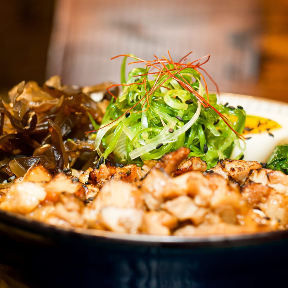 Close-up of a Boru Ramen bowl with chicken, seaweed, and green onions.