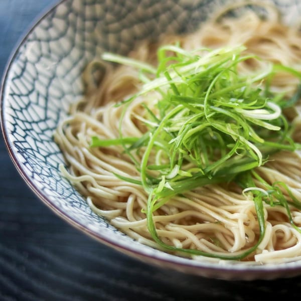 Close-up of Boru Ramen's noodles and broth, topped with fresh green onions in a patterned bowl.