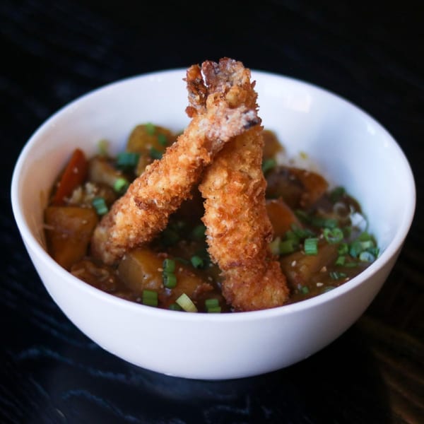Boru Ramen's Japanese curry with two crispy fried shrimp tempura and chopped green onions.