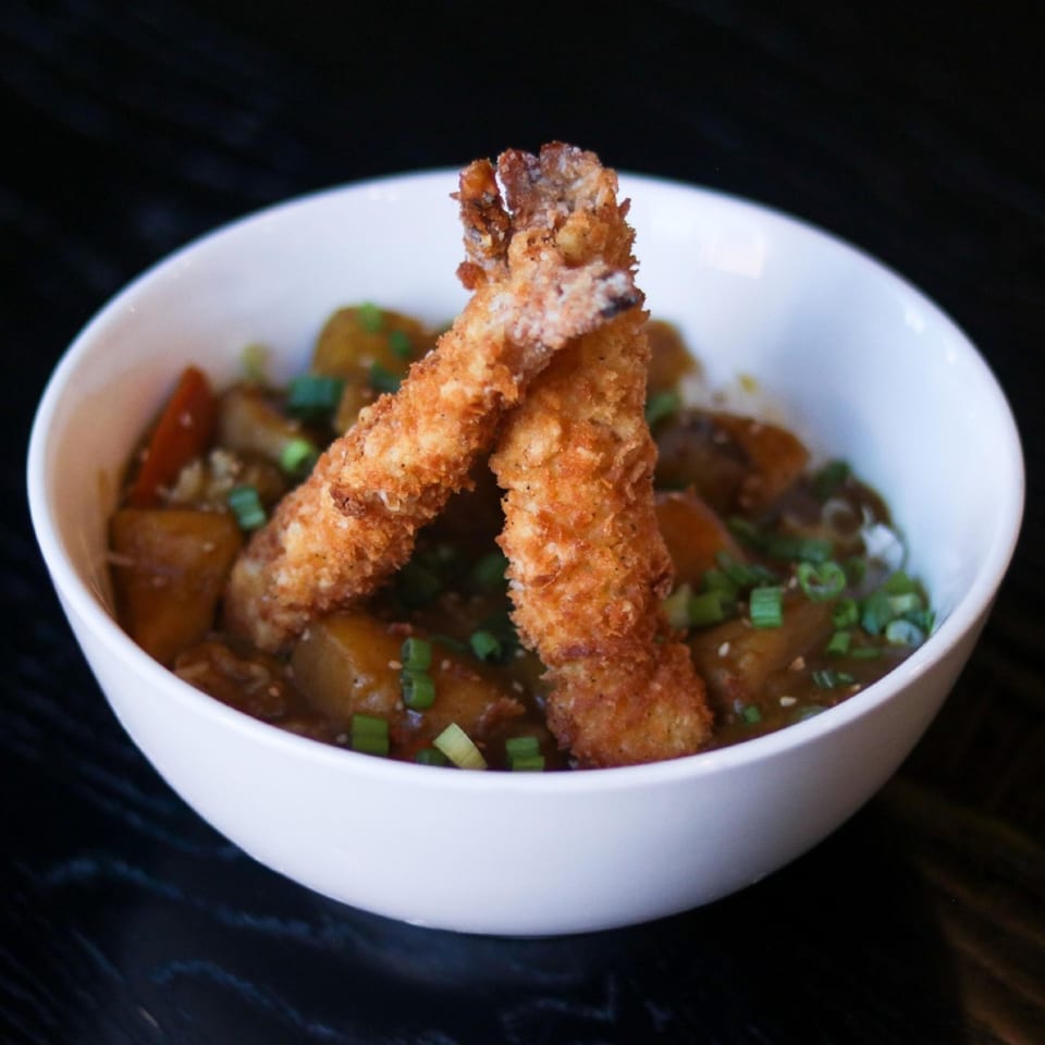Boru Ramen's Japanese curry with two crispy fried shrimp tempura and chopped green onions.