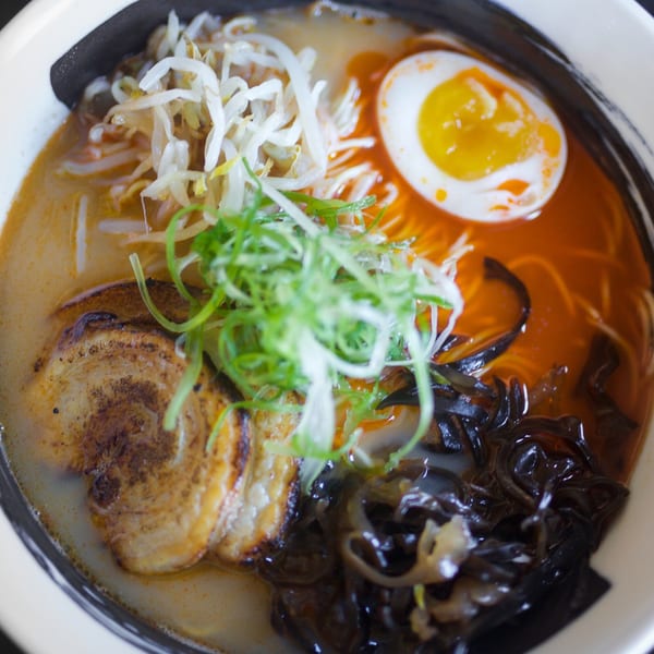 Close-up of Boru Ramen with pork, bean sprouts, green onions, wood ear mushrooms, and a soft-boiled egg.