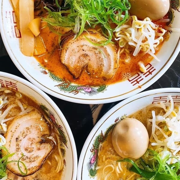 Three bowls of Boru Ramen, topped with pork, eggs, green onions, and bean sprouts.
