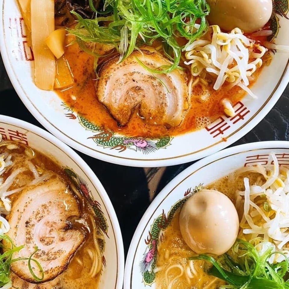Three bowls of Boru Ramen, topped with pork, eggs, green onions, and bean sprouts.