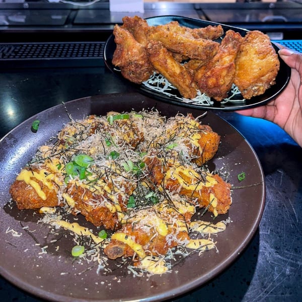 Two plates of Boru Ramen's crispy fried chicken wings, one with sauce and toppings.