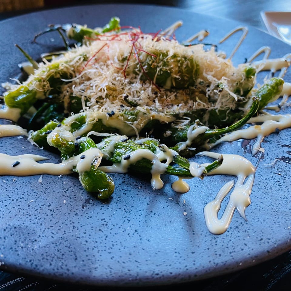 Boru Ramen's green shishito peppers with white sauce, sesame seeds, and shaved bonito flakes.