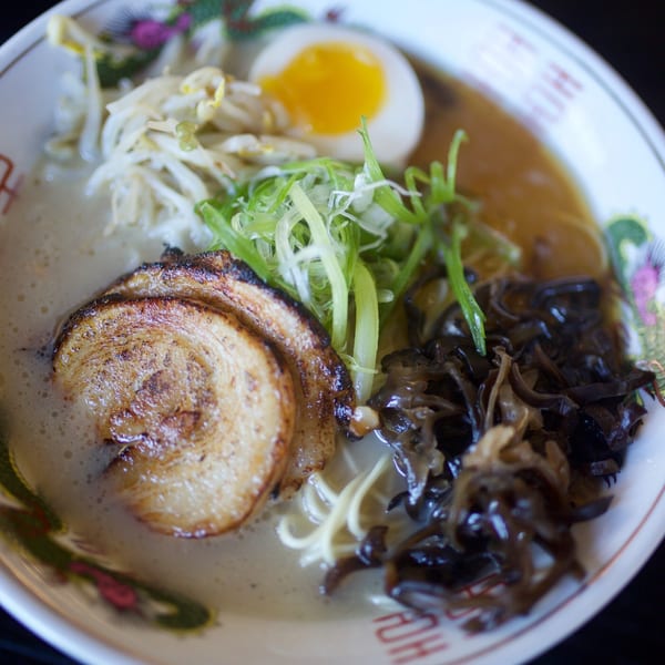 Close-up of Boru Ramen with pork, soft-boiled egg, bean sprouts, green onions, and mushrooms.