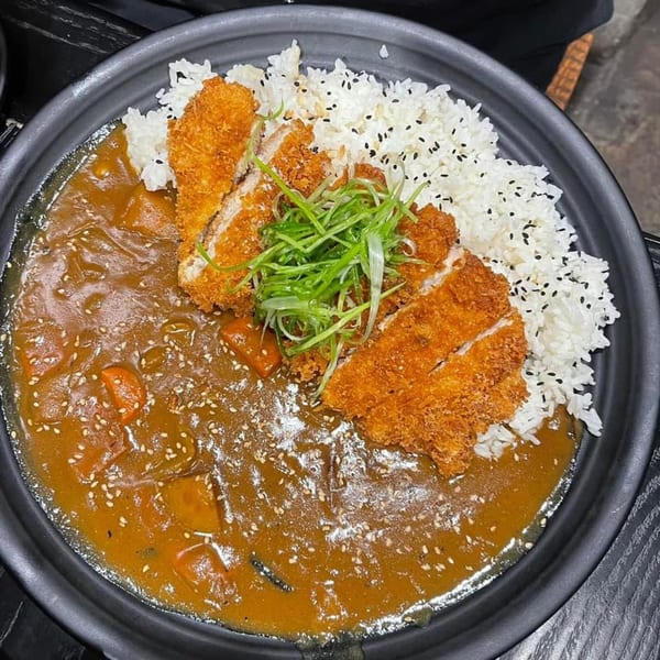 Boru Ramen's chicken katsu curry with white rice, green onions, and sesame seeds.