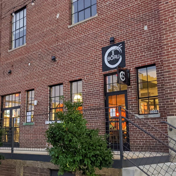 Exterior of Boru Ramen restaurant, a brick building with large windows and a black sign.