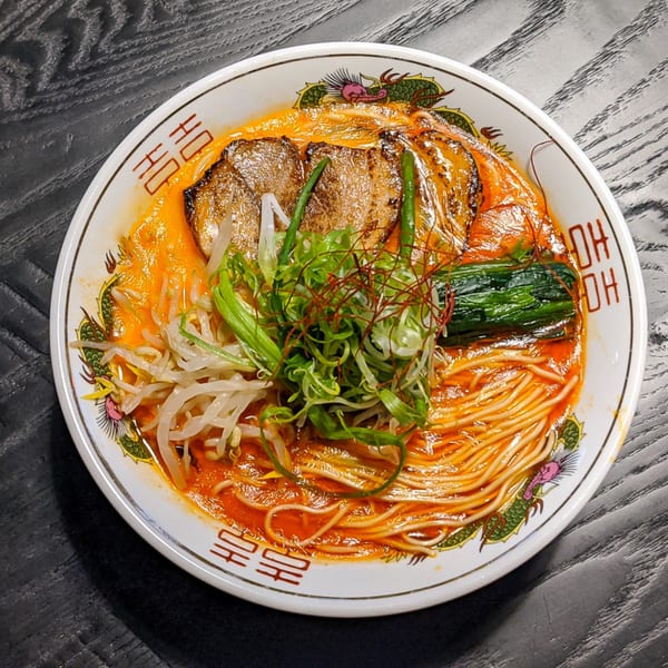 Boru Ramen's spicy ramen with pork, bean sprouts, green onions, and spinach in a decorative bowl.