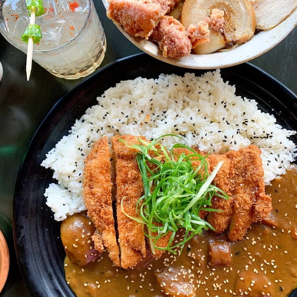 Boru Ramen's chicken katsu curry with rice, topped with green onions and sesame seeds.
