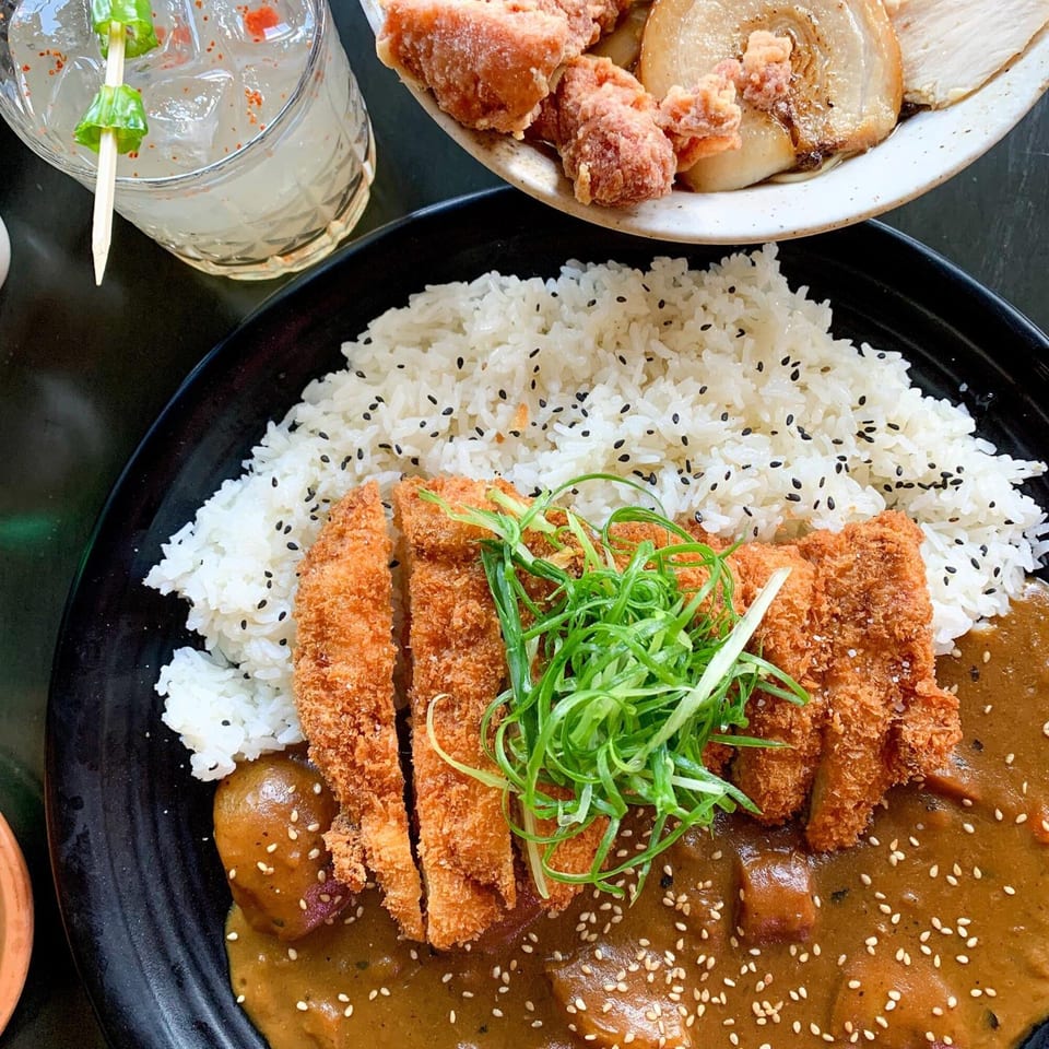 Boru Ramen's chicken katsu curry with rice, topped with green onions and sesame seeds.